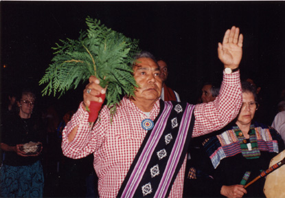 Deacon with pine boughs in his hands in Tekakwitha Conference procession, St. James Cathedral, Seattle Washington, 1993